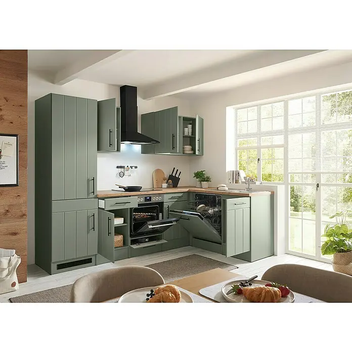 Respekta Winkelküche Anton Typ 1 - 172 x 280 cm, Schilfgrün, Mit Elektrogeräten - Moderne salbeigrüne Küche mit Holztheke, geöffnetem Backofen, Geschirrspüler und Oberschränken, in hellem Raum mit Esstisch.