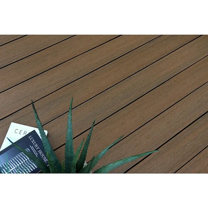 b!design WPC-Terrassendiele - 300 x 14,5 x 2,5 cm, Teak - Braune WPC-Terrassendielen mit Holzmaserung, präsentiert mit Buch und Pflanze.