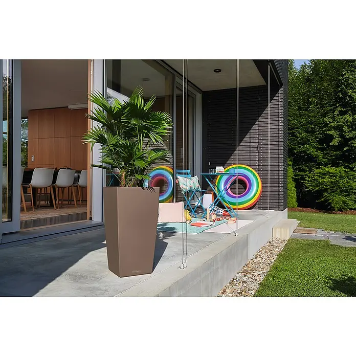 Lechuza Color Pflanzsäule eckig Cubico - Außenmaß (L x B x H): 40 x 40 x 75 cm, Kunststoff, Muskat - Brauner, rechteckiger Pflanzkübel mit grüner Palme auf einer modernen Terrasse.