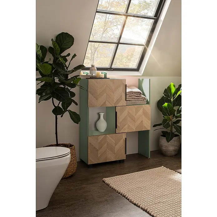 Schildmeyer Piazza Schieberegal - L x B x H: 34,7 x 46,9 x 101,6 cm, Eiche Hell/Pistazie - Moderner Badezimmerschrank mit hellen Fischgrät-Holztüren und grünem Rahmen, offenen Fächern mit Handtüchern und Vase, in sonnigem Bad.