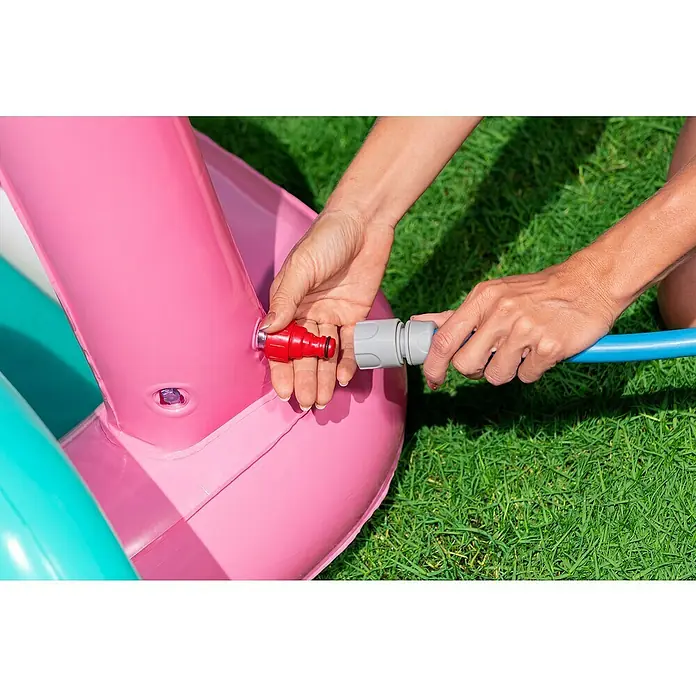 Bestway Planschbecken Wasserspielcenter Schmetterling - 180 x 180 x 117 cm - Hände verbinden blauen Schlauch mit rotem Ventil eines pinken aufblasbaren Pools zum Befüllen.