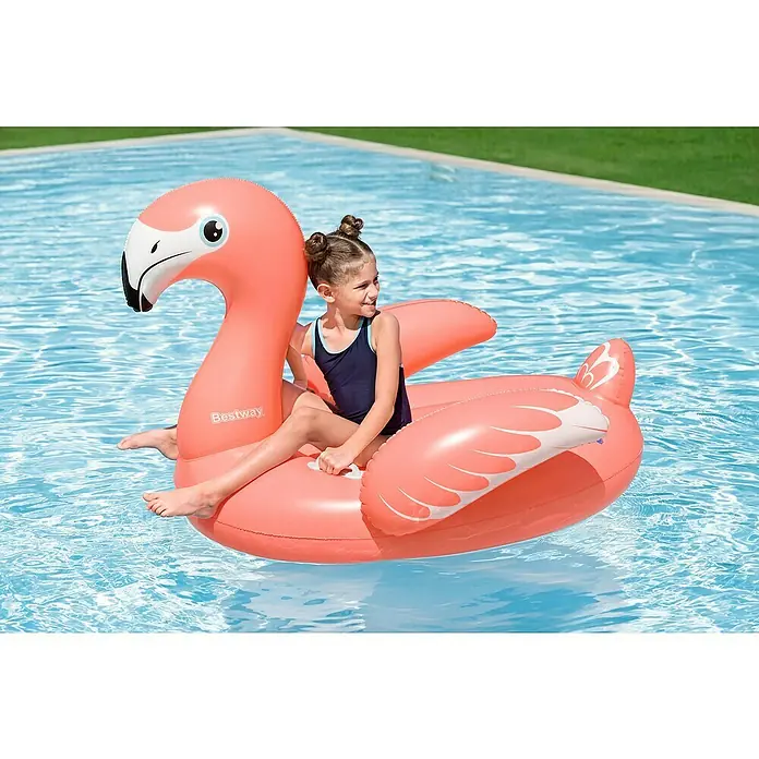 Bestway Schwimmtier Flamingo - 110 x 128 x 87 cm - Rosa Flamingo-Schwimmtier im Pool, das ein Kind in einem marineblauen Badeanzug trägt.