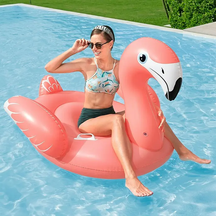 Bestway Schwimmtier Flamingo - 148 x 127 x 99 cm - Rosa aufblasbarer Flamingo-Schwimmreifen im Pool, eine Frau sitzt darauf.