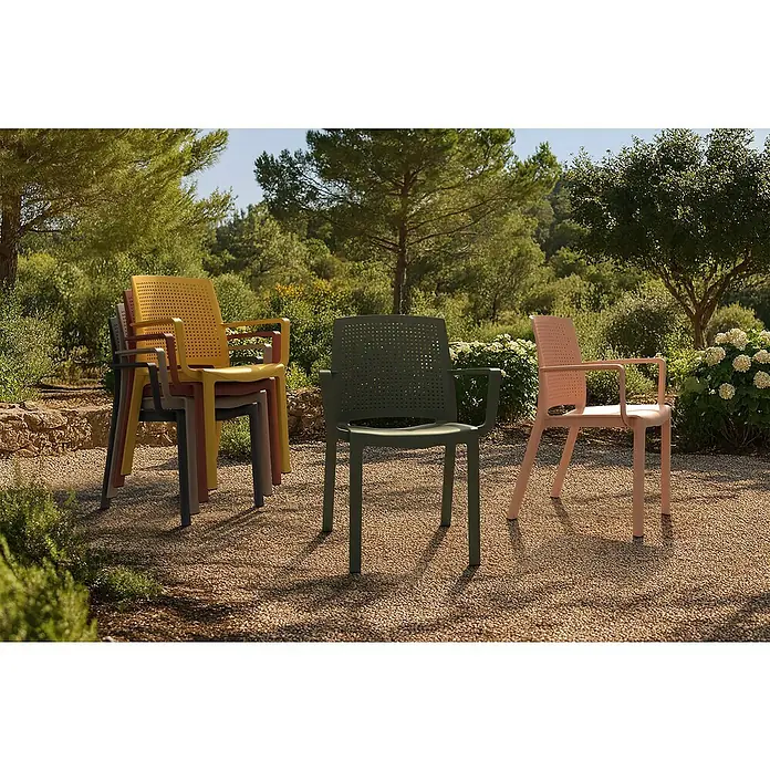Grosfillex Stapelsessel Set Luce - 4 Stk., Polypropylen, Stapelbar, Anthrazit, B x T x H: 58 x 52 x 81 cm - Stapelbare Gartenstühle in verschiedenen Farben (Gelb, Grün, Rosa, Grau, Braun) auf einem Kiesweg in einer Gartenumgebung.