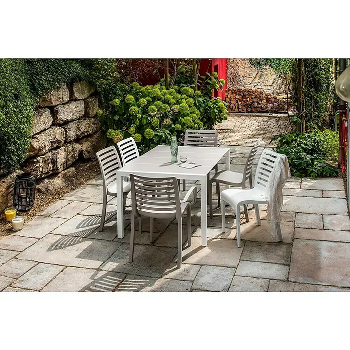 Grosfillex Stapelstuhl Set Slat - 4 Stk., Polypropylen, Stapelbar, Taupe, B x T x H: 53 x 58 x 88 cm - Gartensitzgruppe mit hellgrauem Tisch und Stühlen in Hell- und Dunkelgrau auf einer Steinterrasse.