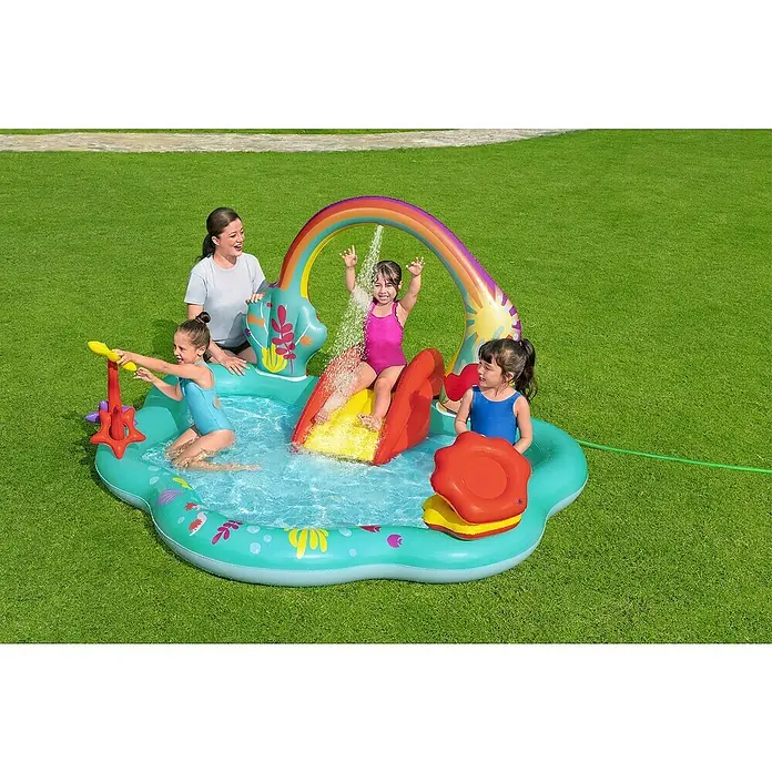 Bestway Planschbecken Kleine Meerjungfrau - 221 x 193 x 117 cm - Buntes aufblasbares Planschbecken mit Rutsche, Regenbogen-Sprinkler und Wasserspielzeug, von Frau und drei Kindern genutzt.