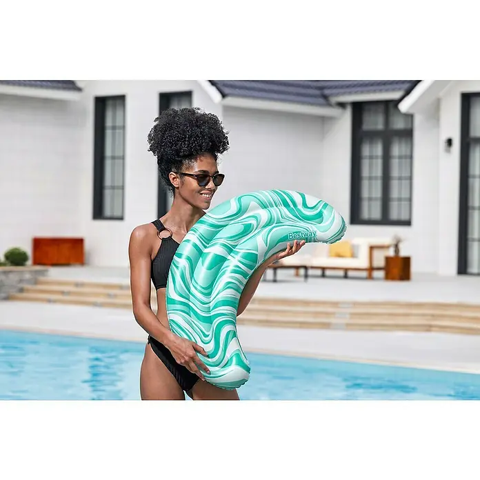 Bestway Schwimmkissen Mondwelle - 47 x 74 x 9 cm, Grün - Bestway hellgrün-weißes aufblasbares Pool-Schwimmkissen mit Wellenmuster, von einer Person am Pool gehalten.