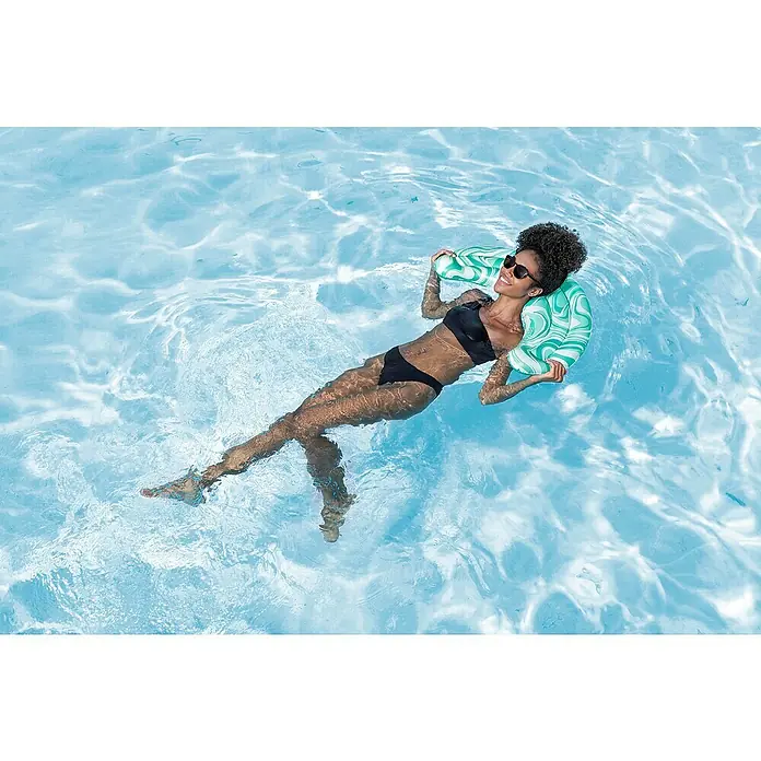 Bestway Schwimmkissen Mondwelle - 47 x 74 x 9 cm, Grün - Grün-weiß gemusterte Pool-Hängematte, die eine Person im Wasser trägt.
