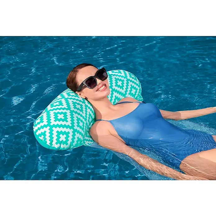 Bestway Luftmatratze Comfort Plus Pool-Hängematte - L x B: 80 x 124 cm - Frau entspannt im Pool auf einem weiß-türkis gemusterten Schwimmkissen.