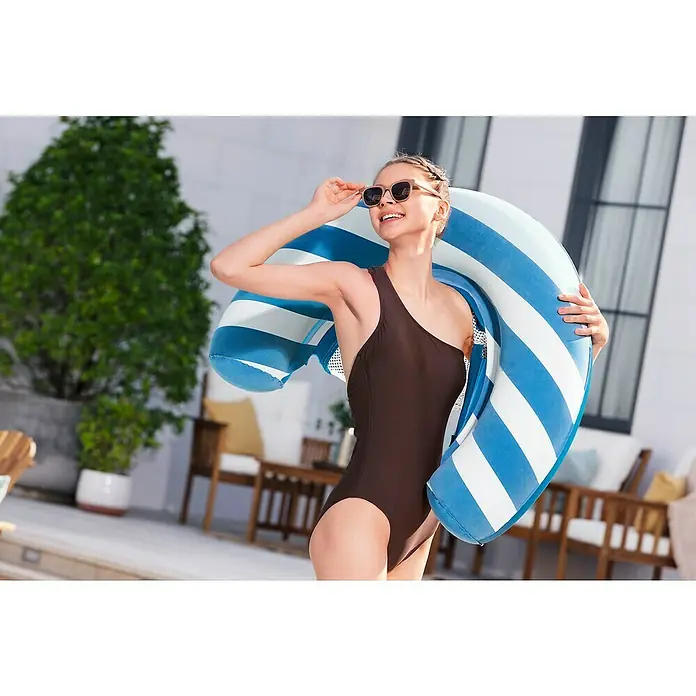 Bestway Luftmatratze Poolsitz mit Textiloberfläche - L x B: 67,5 x 96 cm - Blau-weiß gestreifter Schwimmreifen, von einer Frau im braunen Badeanzug gehalten, bereit zum Schwimmen.
