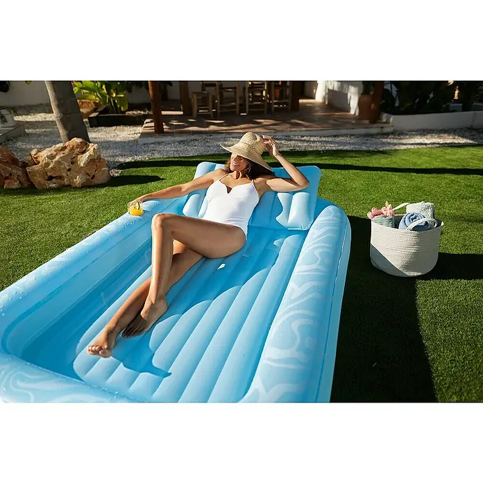 Bestway Luftmatratze Tanning Lounge - L x B: 1,37 x 2,03 m - Blaues aufblasbares Pool-Lounger mit einer darauf entspannenden Frau, die ein Getränk hält.