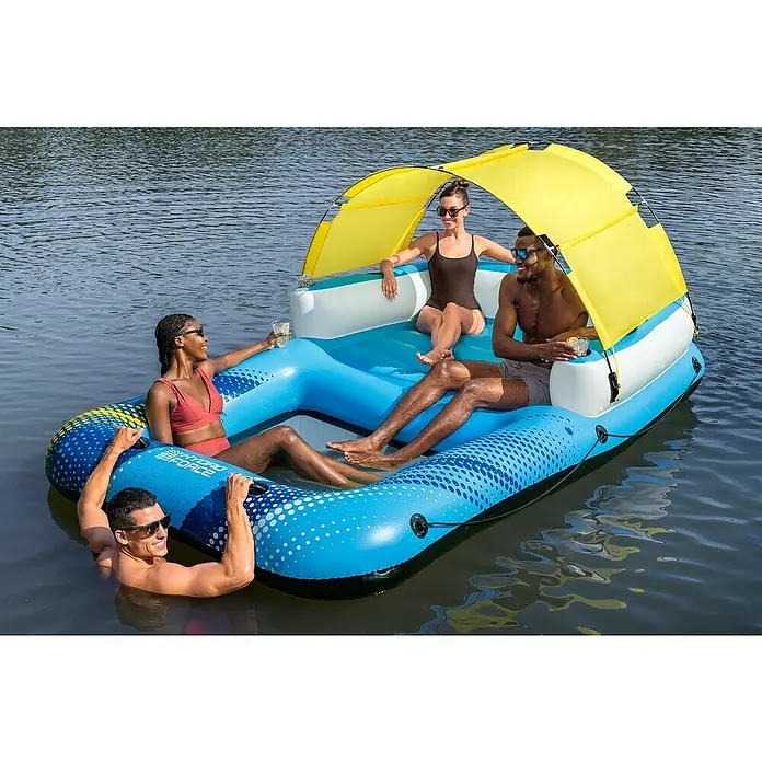 Bestway Schwimminsel Sommerparadies - L x B x H: 305 x 186 x 58 cm - Vier Personen auf einer großen blauen aufblasbaren Schwimminsel mit gelbem Sonnenschutz auf einem See.