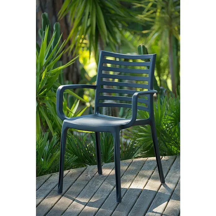 Grosfillex Stapelsessel Set Sunday - 4 Stk., Polypropylen, Stapelbar, Anthrazit, B x T x H: 59 x 56 x 84 cm - Anthrazitfarbener Kunststoff-Outdoorstuhl mit Armlehnen und Lattenrücken auf einer Holzterrasse.