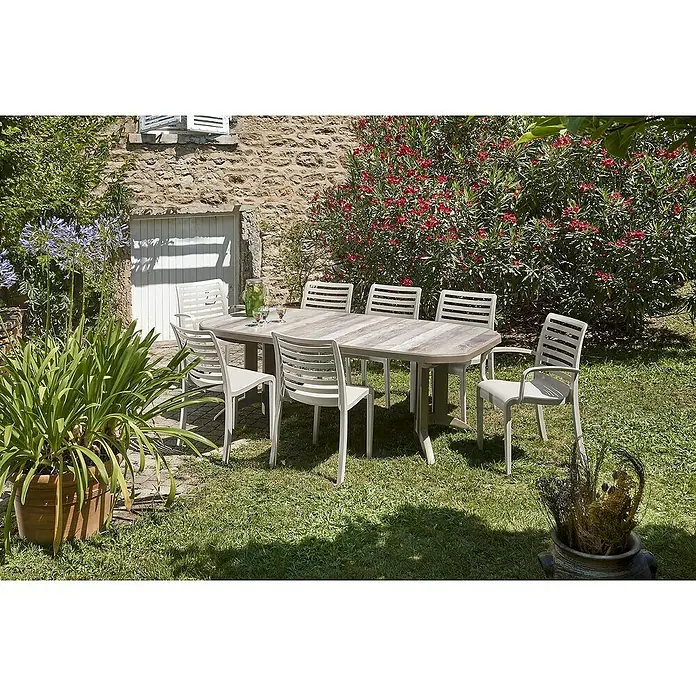 Grosfillex Stapelsessel Set Slat - 4 Stk., Polypropylen, Stapelbar, Beige, B x T x H: 60 x 58 x 88 cm - Ein heller Esstisch in Holzoptik für den Außenbereich mit acht hellgrauen Stühlen auf einem Rasen.