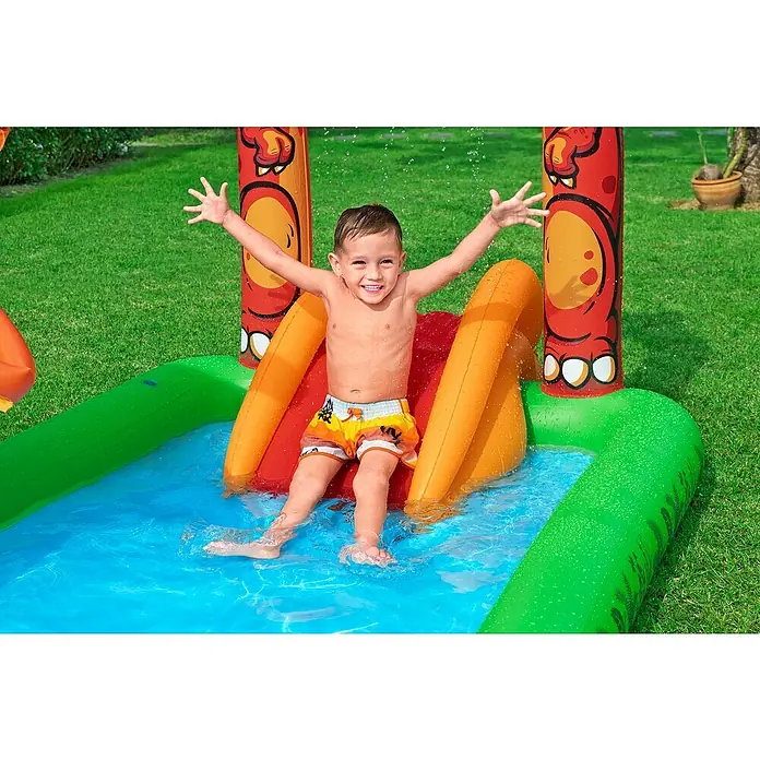 Bestway Planschbecken Jurassic Splash - 241 x 140 x 137 cm - Fröhlicher Junge spielt in einem farbigen aufblasbaren Wasserpark mit Rutsche, mit grünen, blauen, roten und orangefarbenen Bereichen.