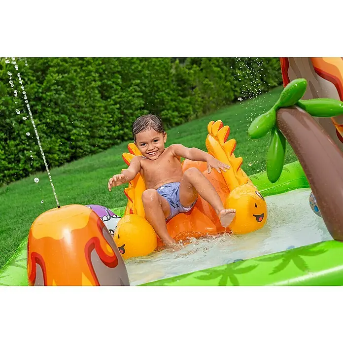 Bestway Planschbecken Wasserspielcenter Vulkan - 188 x 262 x 102 cm - Kleinkind spielt in aufblasbarem Wasserpark mit Dinosaurier-Motiv, Rutsche und spritzendem Wasser.