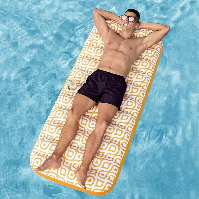 Bestway Luftmatratze mit Samtoberfläche - L x B: 77,5 x 169 cm - Mann entspannt auf gelb-weißem Poolliege mit geometrischem Muster im Wasser, mit Getränk im Halter.