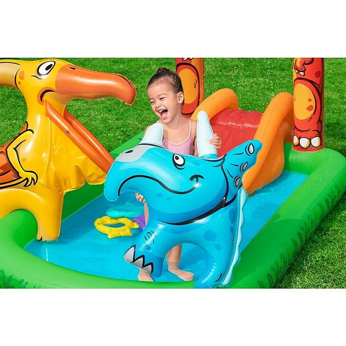 Bestway Planschbecken Jurassic Splash - 241 x 140 x 137 cm - Ein glückliches Kind spielt in einem farbenfrohen, aufblasbaren Dinosaurier-Wasserspielcenter mit gelbem Flugsaurier und blauem Dinosaurier.