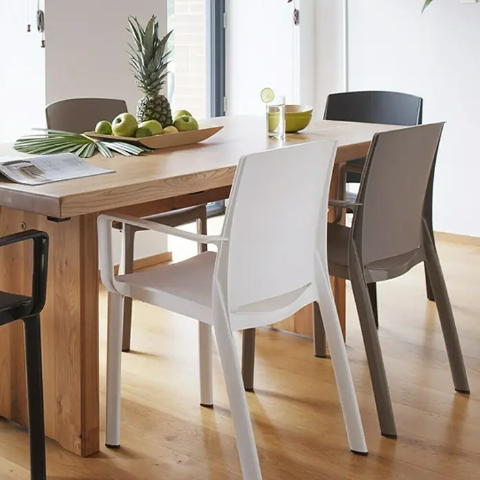 Grosfillex Stapelsessel Set Milton - 4 Stk., Polypropylen, Stapelbar, Weiß, B x T x H: 58 x 52 x 81 cm - Moderne Esszimmerstühle in Weiß, Taupe und Schwarz, um einen Holztisch in einem modernen Ambiente arrangiert.