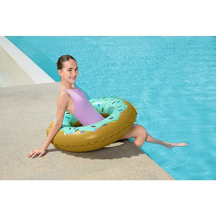 Bestway Schwimmring Donut - Braun/Türkis - Ein aufblasbarer, donut-förmiger Poolschwimmer in Gold und Hellblau mit bunten Streuseln, von einer Person in einem Schwimmbecken benutzt.