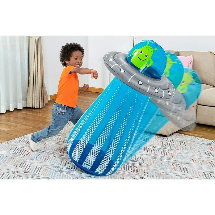 Bestway Boxsack UFO mit Wassersprinkler - Blau - Kleines Kind schlägt auf aufblasbares blau-graues UFO-förmiges Spielzeug mit grünem Alien.