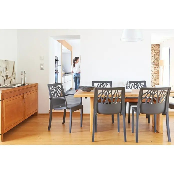 Grosfillex Stapelsessel Set Vegetal - 4 Stk., Polypropylen, Anthrazit, B x T x H: 60 x 58 x 88 cm - Dunkelgraue Esszimmerstühle mit geometrischen Rückenlehnen um einen Holztisch in einem modernen Zuhause.