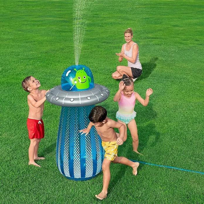 Bestway Boxsack UFO mit Wassersprinkler - Blau - Kinder spielen fröhlich mit einem blauen, grauen aufblasbaren Alien-UFO-Sprinkler, der draußen Wasser sprüht.