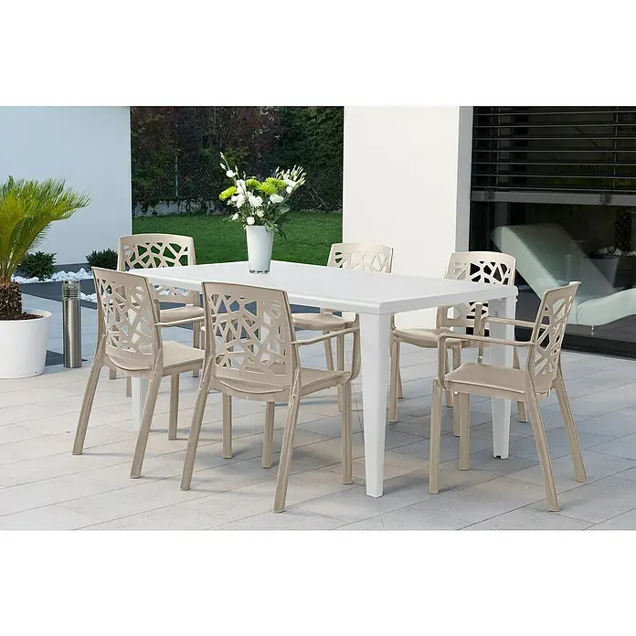 Grosfillex Stapelsessel Set Stuart - 4 Stk., Polypropylen, Stapelbar, Beige, B x T x H: 58 x 52 x 81 cm - Weißer Gartentisch mit sechs beigefarbenen Stühlen mit geometrisch gemusterten Rückenlehnen, auf einer Terrasse.
