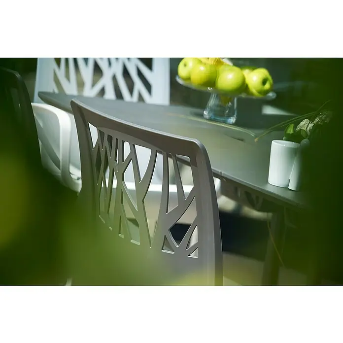 Grosfillex Stapelstuhl Set Vegetal - 4 Stk., Polypropylen, Anthrazit, B x T x H: 60 x 58 x 88 cm - Moderner grauer Stuhl mit geometrischer Rückenlehne an einem Tisch.