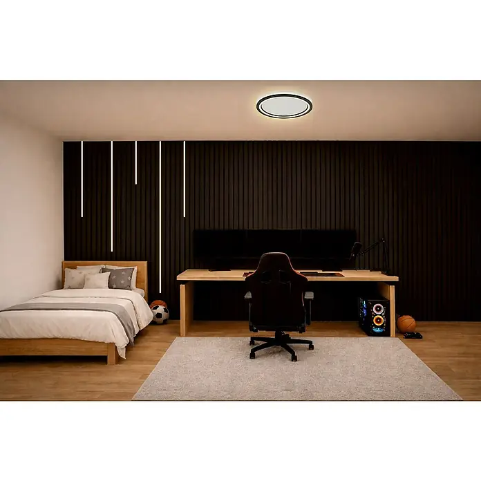 Direct Signs LED-Deckenleuchte rund Tobi Akus - 48 W, Ø x H: 44,4 cm x 43 mm, Schwarz, Warmweiß - Eine moderne, runde Deckenleuchte in Schwarz-Weiß erhellt ein Schlafzimmer mit Gaming-Setup.