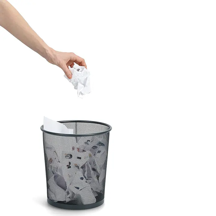 Zeller Present Papierkorb Mesh - Ø x H: 26 x 28 cm, Metall, Anthrazit - Eine Hand wirft zerknülltes Papier in einen schwarzen Metall-Mülleimer aus Netz, der halbvoll mit Papier ist.