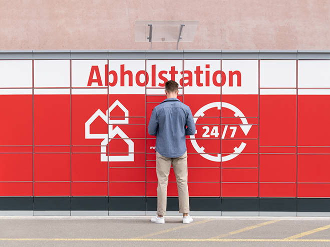 Mann steht vor einer BAUHAUS Abholstation