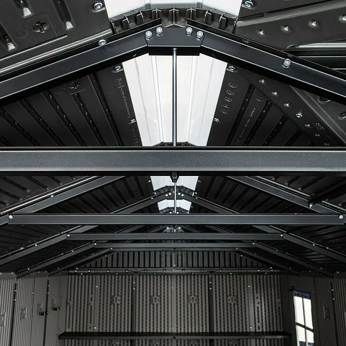 Lifetime Gerätehaus Idaho - Kunststoff, Grau, Außenmaß inkl. Dachüberstand (B x T): 498 x 214 cm - Innenansicht eines Schuppens mit dunkelgrauem Metalldachrahmen, lichtdurchlässigen Oberlichtern und hellen Wellwänden. Regale sichtbar.