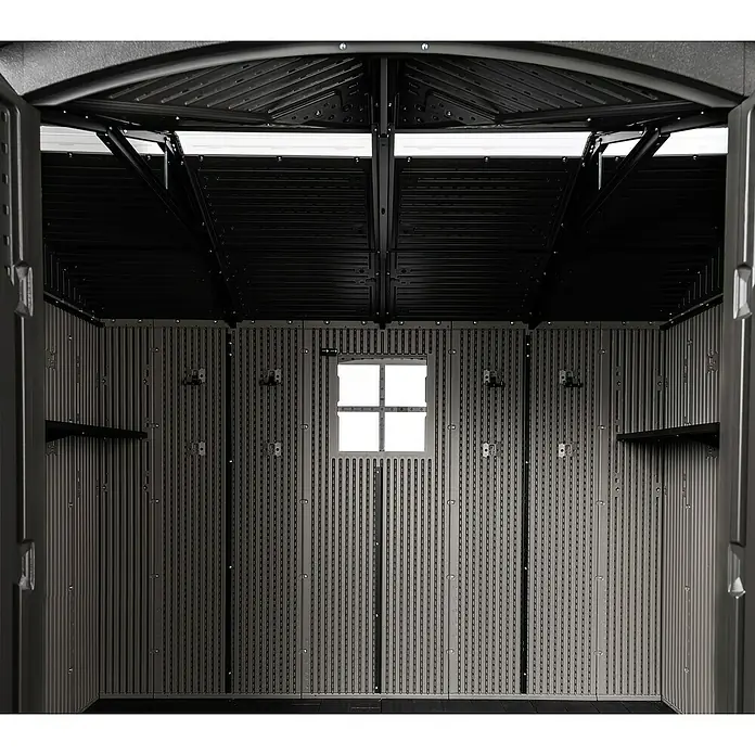 Lifetime Gerätehaus Ohio - Kunststoff, Grau, Außenmaß inkl. Dachüberstand (B x T): 283,5 x 214,1 cm - Dunkelgraues Kunststoff-Gartenhaus-Interieur mit gerippten Wänden, einem hellen Fenster und zwei integrierten schwarzen Regalen.