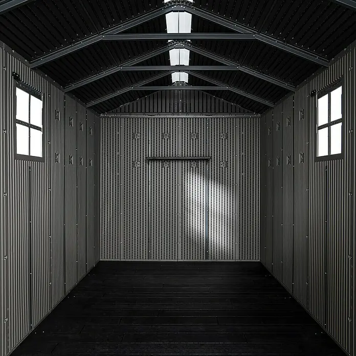 Lifetime Gerätehaus Utah - Kunststoff, Grau, Außenmaß inkl. Dachüberstand (B x T): 206 x 427 cm - Leerer, dunkelgrauer Geräteschuppen-Innenraum mit Wellwänden, dunklem Boden, Fenstern und Oberlichtern.
