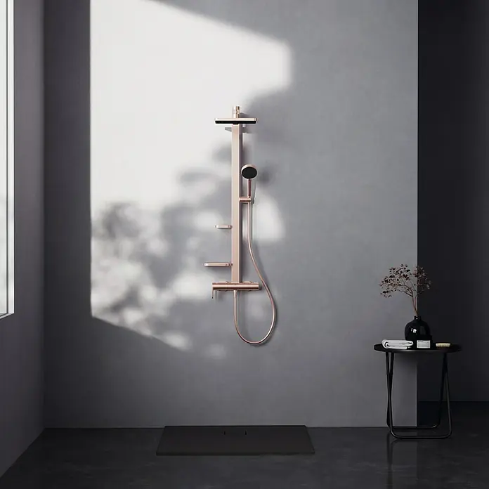 Ideal Standard Alu+ Duschsystem Ceraflow BE204RO - Lochabstand: 60 cm, Anzahl Strahlarten: 2 Stk., Rose, Form Kopfbrause: Eckig - Modernes Duschsystem in Roségold mit Kopf- und Handbrause, über einer schwarzen Duschwanne installiert.