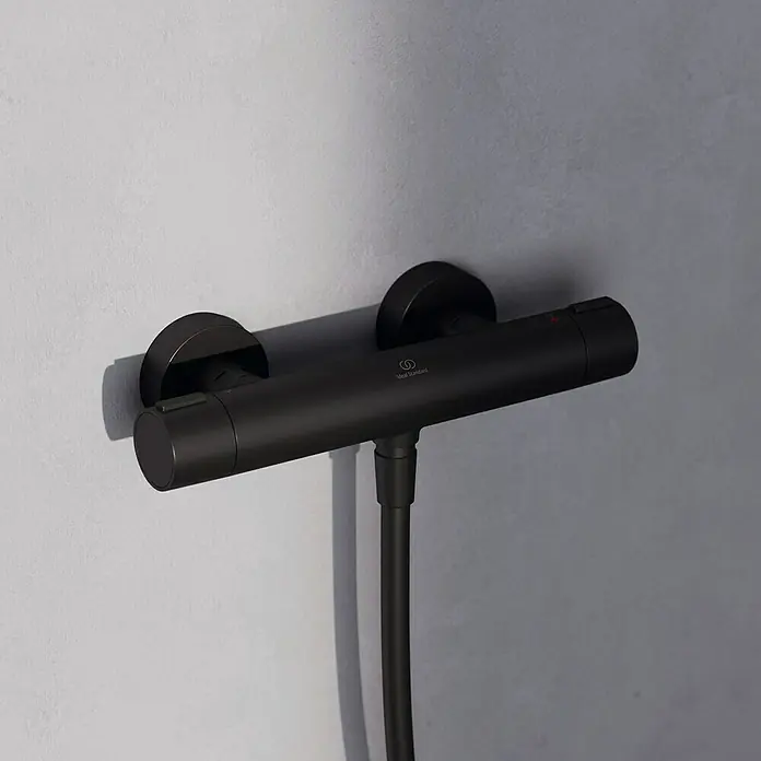 Ideal Standard Alu+ Brausegarnitur Ceratherm - Lochabstand: 40 cm - 50 cm, Art Strahl: SilkRain, Rain, Schwarz - Mattschwarze wandmontierte Thermostat-Duscharmatur mit Schlauchanschluss und zwei Drehreglern, mit Ideal Standard Logo.