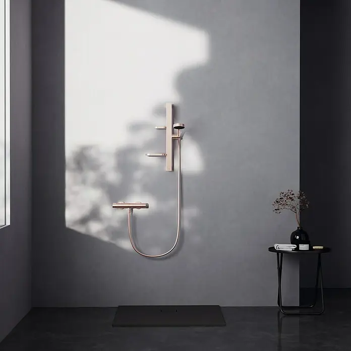 Ideal Standard Alu+ Brausegarnitur Ceratherm - Lochabstand: 40 cm - 50 cm, Art Strahl: SilkRain, Rain, Rosé - Roségoldene Duscharmatur mit Handbrause und Mischer in einem modernen Badezimmer.