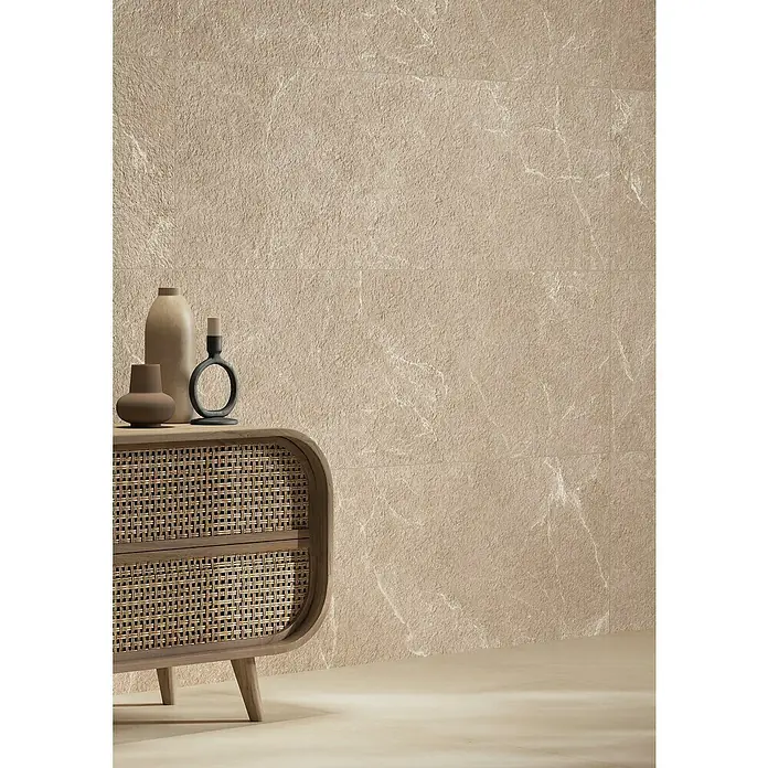Wandfliese Benora - 39,8 x 119,8 cm, Beige Struktur, Matt - Holz-Rattankommode mit Deko-Objekten in einem beigen Raum.