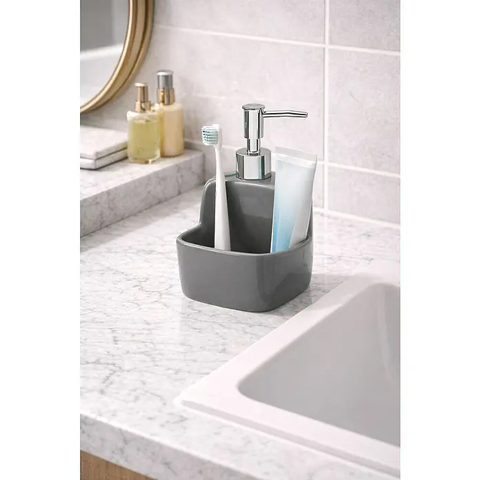 Versa Dispensador de jabón Aqua Karslen - Cerámica Soft-Touch, Gris - Dispensador de jabón gris con caddy integrado para cepillo de dientes y pasta dental, sobre un mostrador de baño.
