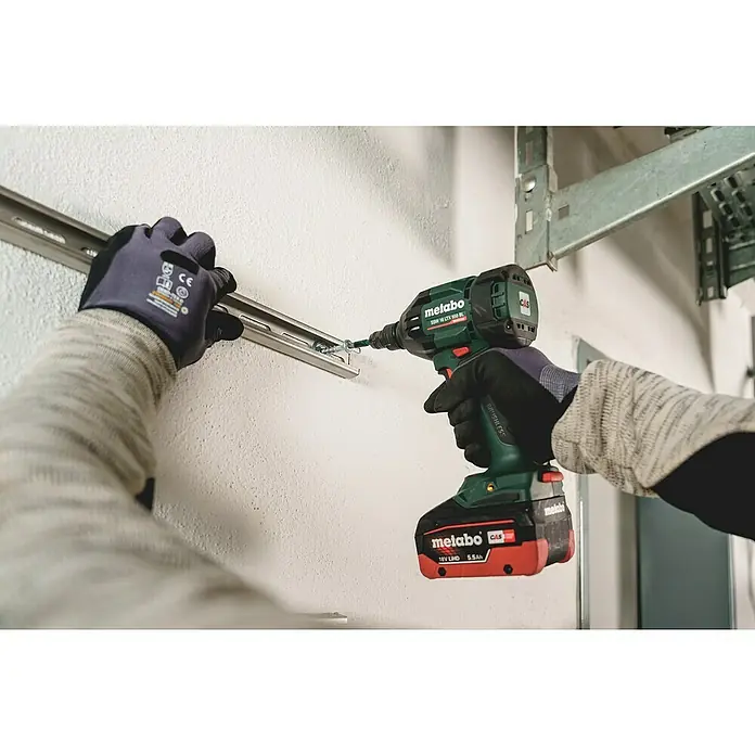 Metabo Akku-Schlagschrauber SSW 18 LTX 550 BL - 18 V, Ohne Akku, Max. Schlagzahl: 3.600 /min - Metabo Akku-Schlagschrauber, grün-schwarz, mit rotem Akku, befestigt eine Metallschiene an einer Wand.