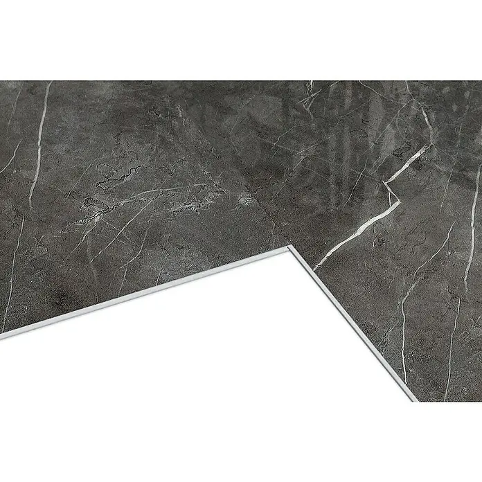 Dumawall+ Revestimiento de pared de PVC Chill Gloss - 75 x 45 cm, Gris - Superficie de mármol gris oscuro con vetas blancas, una esquina parcialmente oculta por una lámina blanca con borde claro.