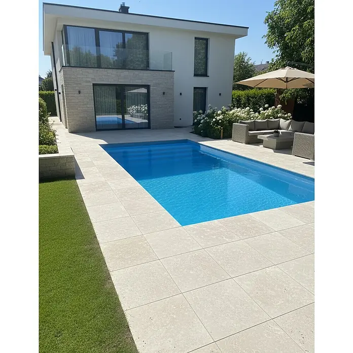 Mountfield Bausatz-Pool - L x B x H: 760 x 390 x 150 cm, 31,75 m³, Blau - Beige Steinfliesen umgeben einen leuchtend blauen Pool in einem modernen Garten.