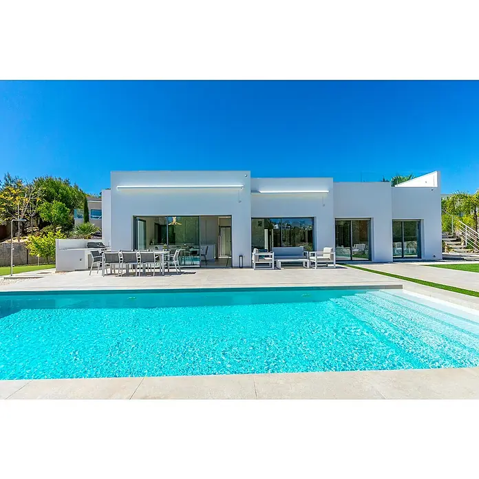 Mountfield Bausatz-Pool - L x B x H: 650 x 350 x 150 cm, 23,83 m³, Weiß - Moderne weiße Villa mit großen Glastüren, Außenterrasse und einem funkelnden blauen Pool, umgeben von Grünflächen unter klarem Himmel.