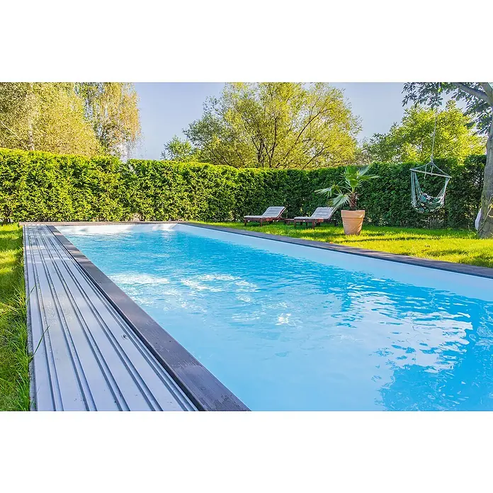 Mountfield Bausatz-Pool - L x B x H: 650 x 350 x 150 cm, 23,83 m³, Weiß - Ein Außenpool mit blauem Wasser, teilweise von einer grauen Lamellenabdeckung in einem sonnigen Garten bedeckt.