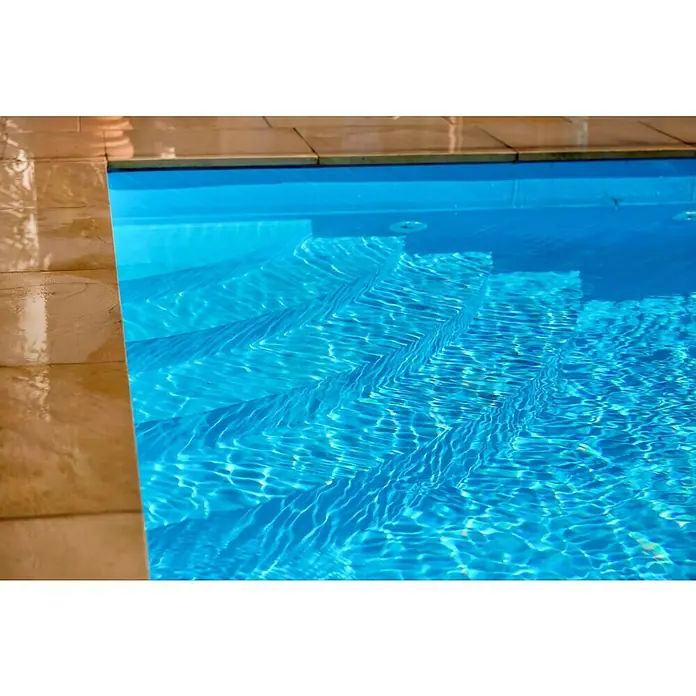 Mountfield Bausatz-Pool - L x B x H: 490 x 350 x 140 cm, 17,59 m³, Blau - Blaues Schwimmbecken mit Treppe und welligem Wasser neben beigefarbenen Fliesen.