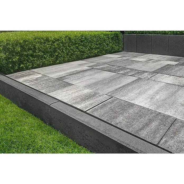 EHL EIBA Rasenkante - 80 x 5 x 20 cm, Anthrazit, Beton - Graue, texturierte Pflastersteine und eine dunkle Umrandung bilden eine elegante Terrasse neben Hecke und Rasen.