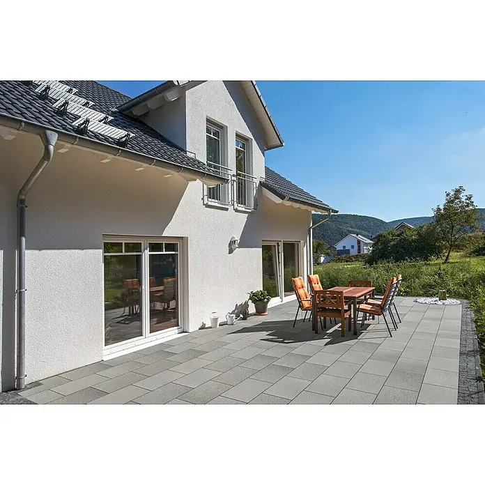 EHL Terrassenplatte Mesafino - 60 x 40 x 4 cm, Stahlgrau, Beton - Rechteckige graue Terrassenplatten schaffen einen modernen Außenbereich neben einem Haus, mit einer Esstischgruppe.