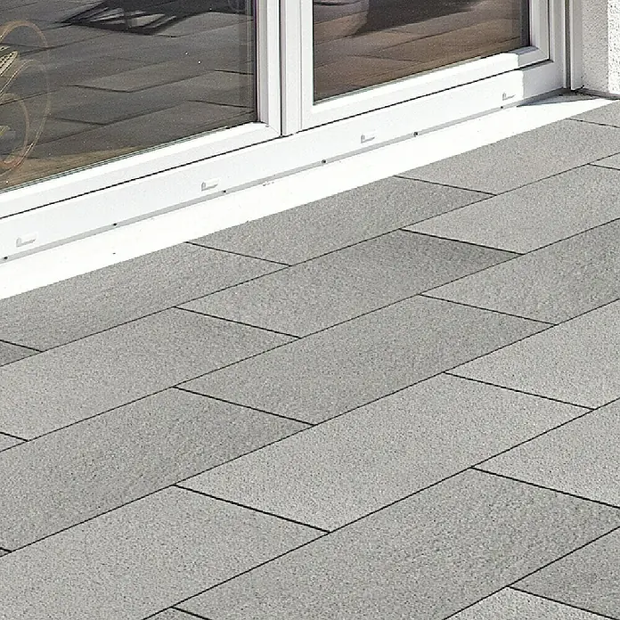 EHL Terrassenplatte Mesafino - 60 x 40 x 4 cm, Stahlgrau, Beton - Graue rechteckige Pflasterplatten bilden eine Terrasse neben einem weißen Fensterrahmen.