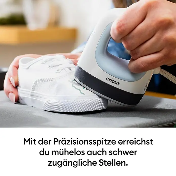 Cricut Transferpresse EasyPress Mini - Passend für: Bügelfolien, Drucktechnologie: Wärmeübertragung - Eine Person nutzt eine weiß-graue Cricut EasyPress Mini Hitzepresse mit Präzisionsspitze, um ein Design auf einen weißen Canvas-Schuh aufzubringen.